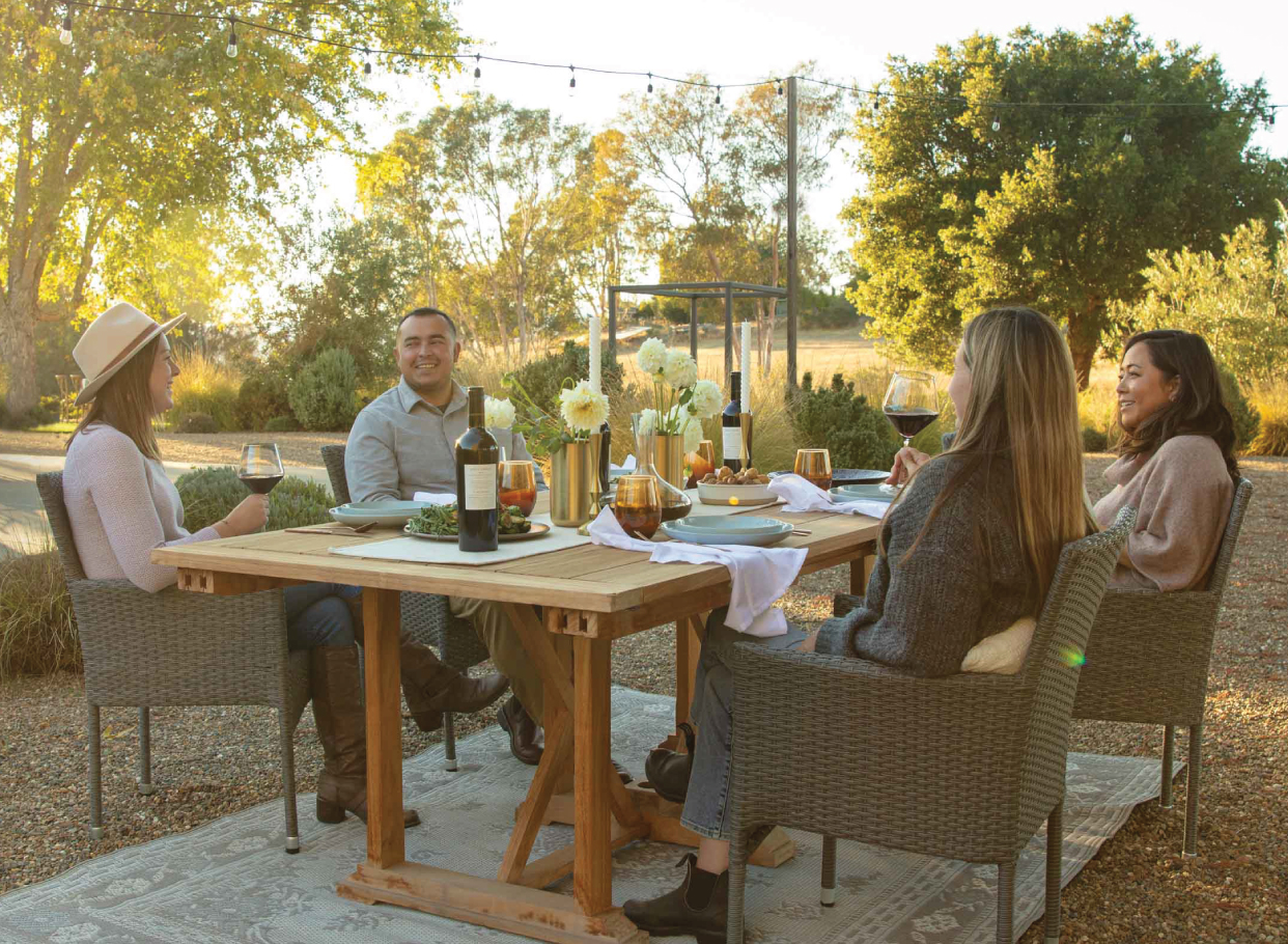 People seated around a table enjoying Flora Springs wine.