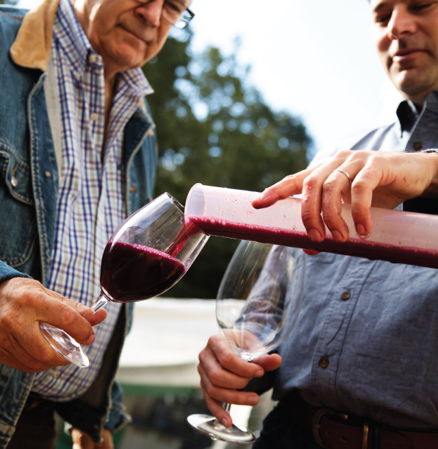 Nat Komes Pouring Wine for John Komes.