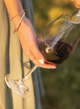 Person holding a glass of Flora Springs red wine.